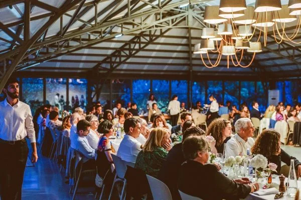 Salle de réception Mas Aubrilha lors d'un dîner de mariage en Hérault avec lumière bleue et invités attablés