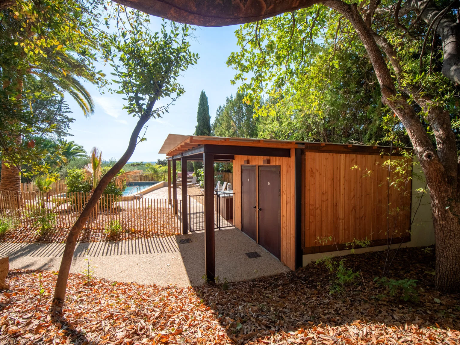 Terrasse avec fauteuils design roses donnant sur la piscine du Mas Aubrilha, domaine de mariage en Hérault