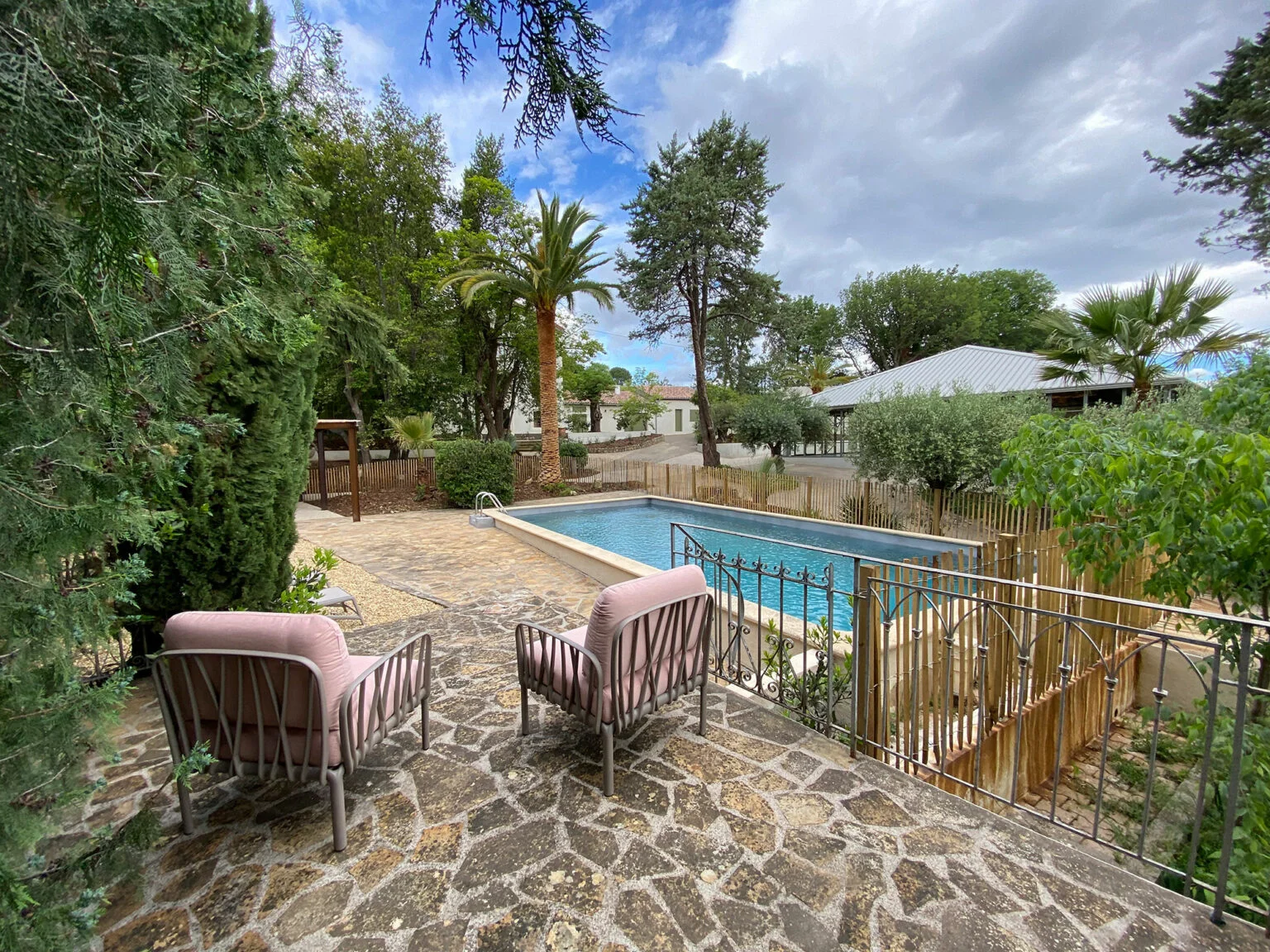 Vue aérienne grand angle du Mas Aubrilha entouré de vignobles avec la plaine héraultaise et la montagne Saint-Loup en arrière-plan