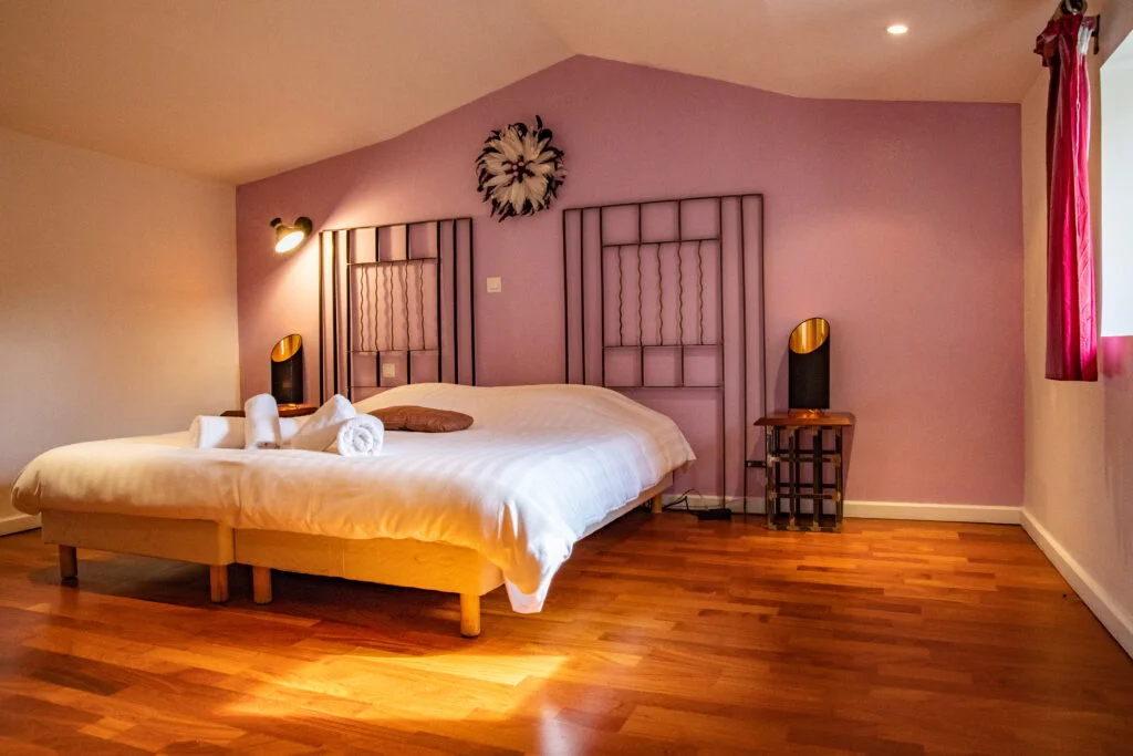 Chambre double au Mas de Baumes avec grand lit, parquet chêne et décoration rose, hébergement mariage Hérault