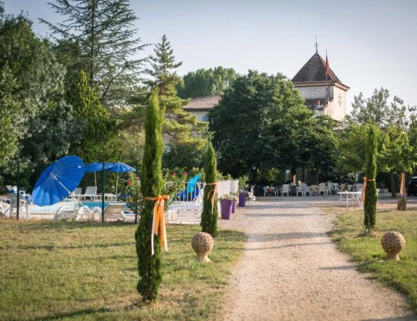 Allée de cyprès décorée menant au château du Mas de Pradines lors d'un mariage en Hérault