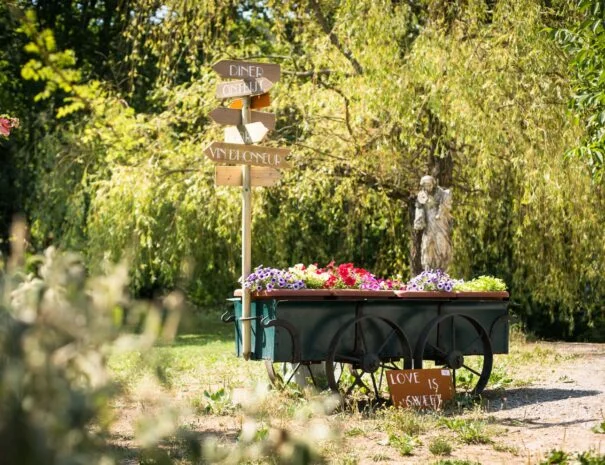 Chariot fleuri avec pancartes directionnelles décoratives pour mariage au Mas de Pradines, Hérault