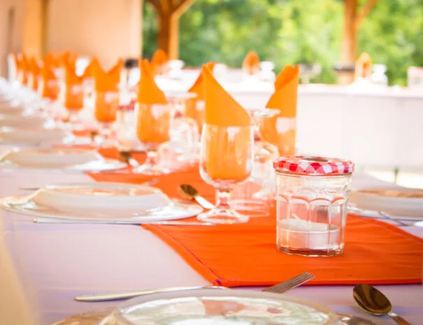 Dressage de table mariage avec chemin orange et verres à pied au Mas de Pradines, Hérault