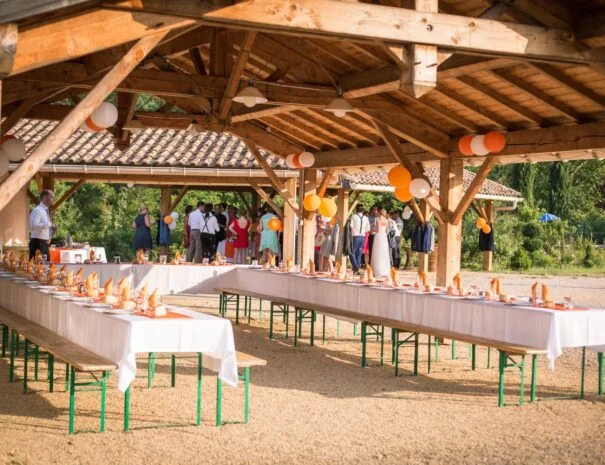 Réception de mariage dans la halle en bois décorée de ballons au Mas de Pradines, Hérault