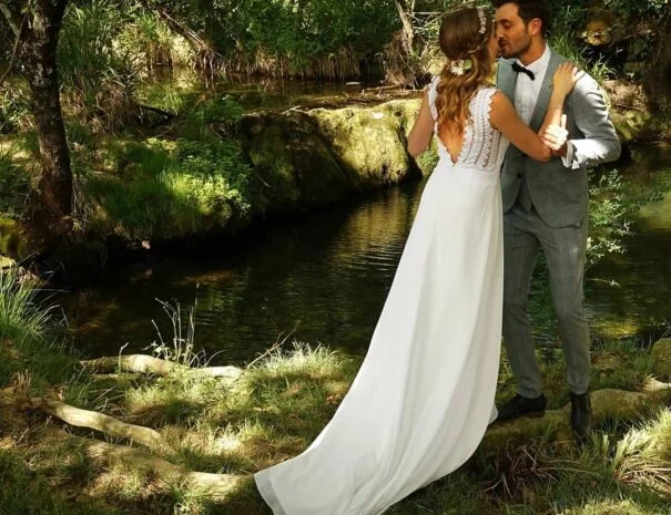 Couple de mariés s'embrassant au bord d'un ruisseau dans le domaine du Mas de Pradines, Hérault