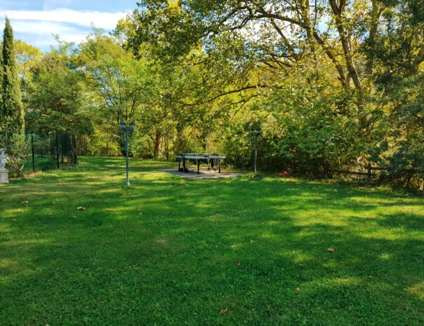 Grande pelouse ombragée avec pergola en fer forgé au Mas de Pradines - Espace mariage en plein air Hérault