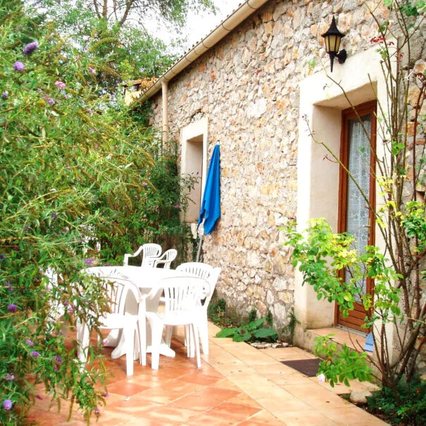 Terrasse fleurie d'un gîte en pierre du Mas de Pradines, location mariage Hérault