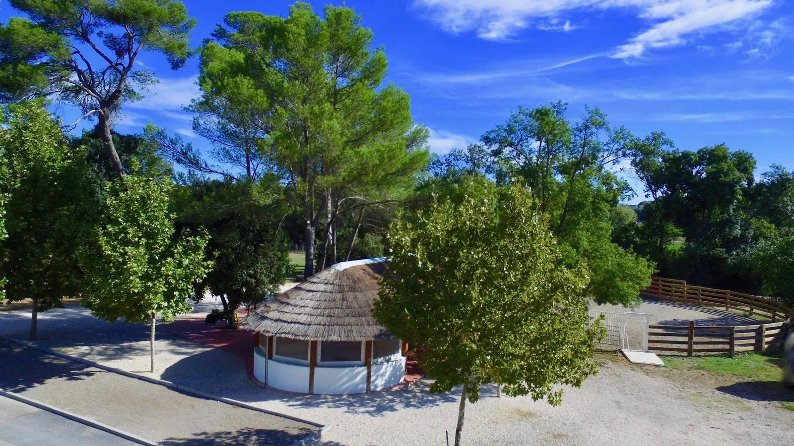 Mas du Pont Hérault - cabane ronde toit de chaume entourée de pins méditerranéens et paddock