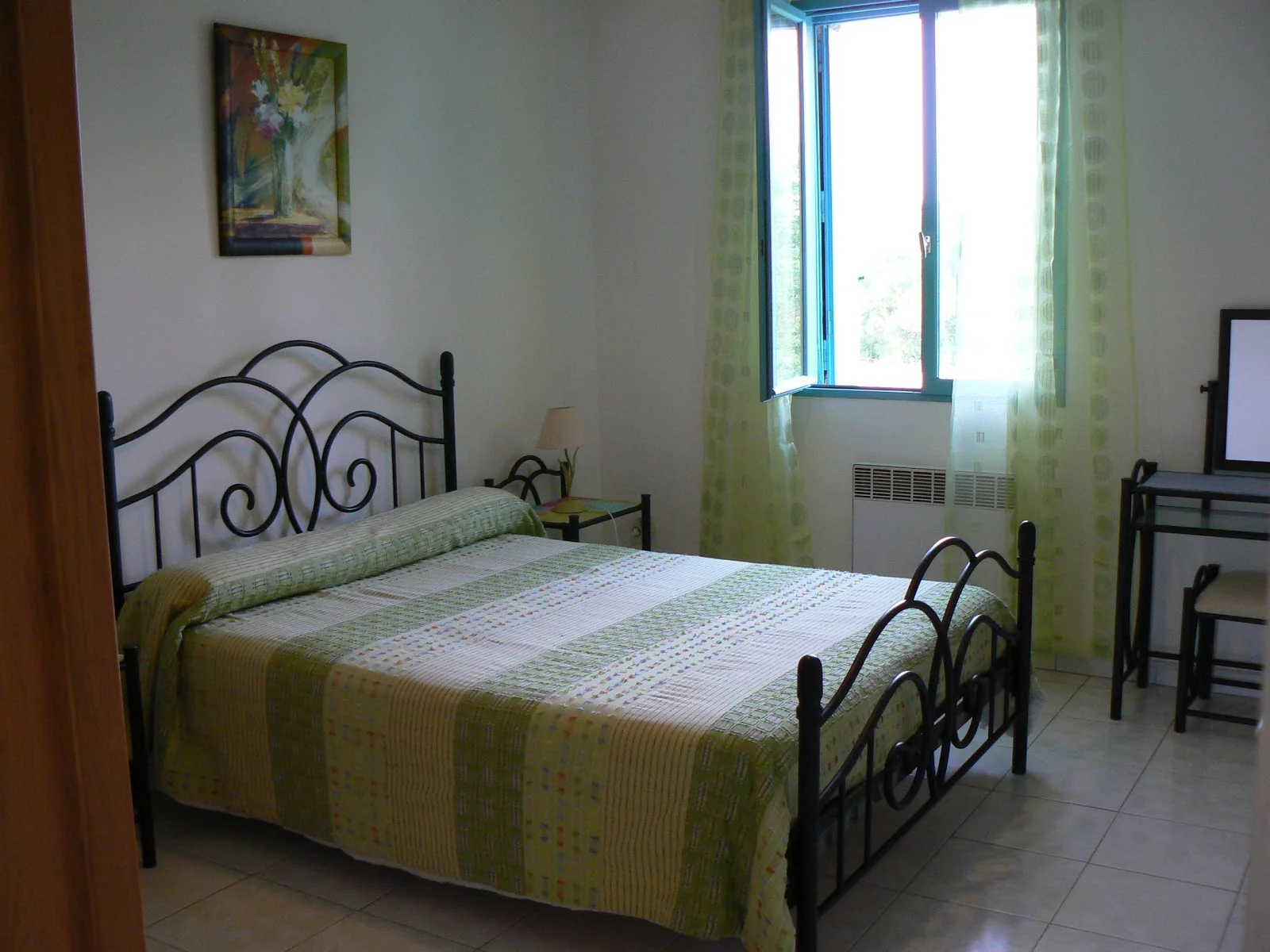 Mas du Pont Hérault - chambre double lit en fer forgé literie verte et vue sur le jardin