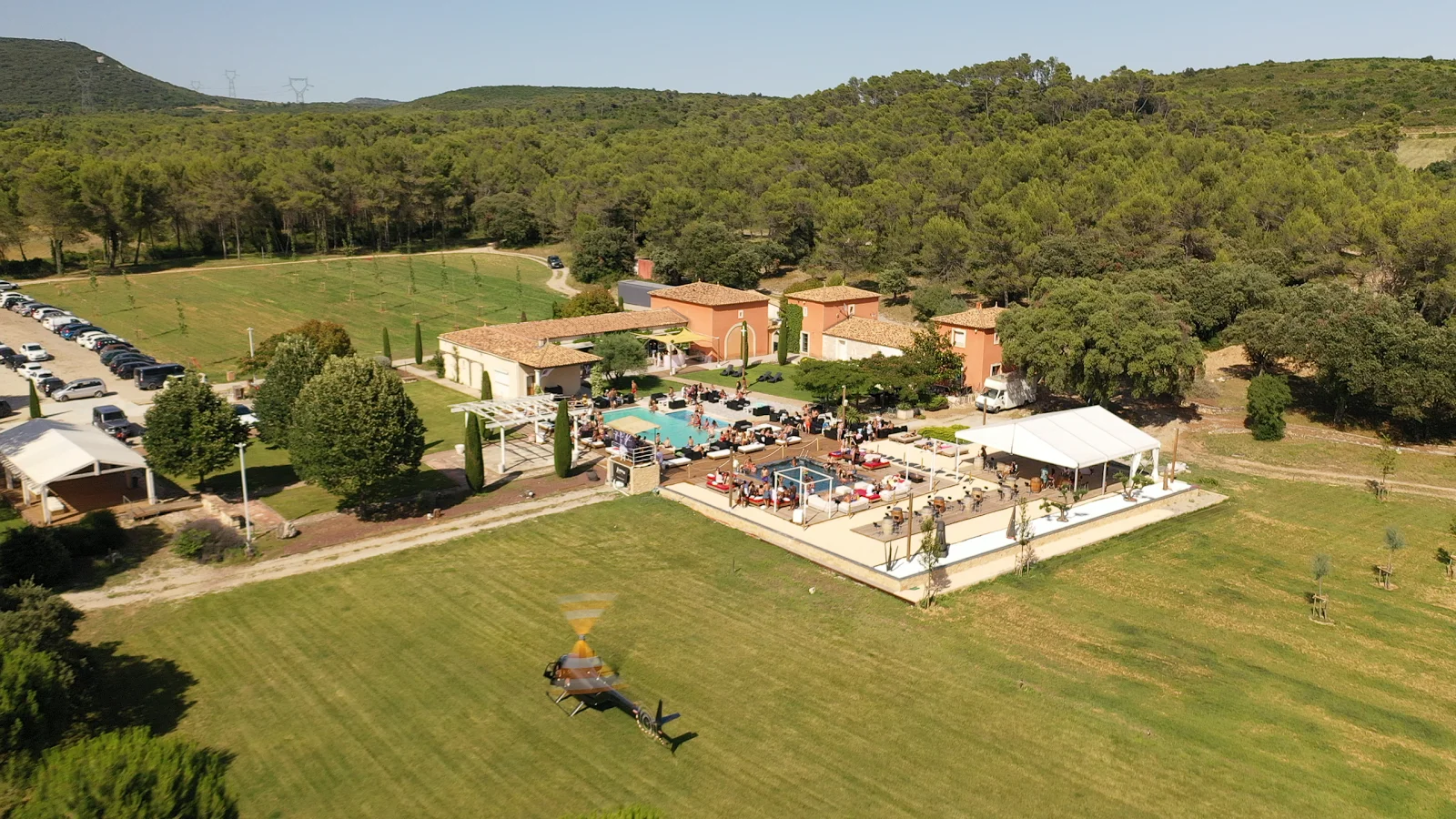 Vue aérienne du Mas Guilhem entouré de forêt méditerranéenne avec pelouse et parking en Hérault