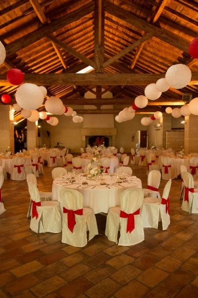 Salle réception Mas La Mourade décoration rouge et blanc lanternes charpente bois mariage Hérault