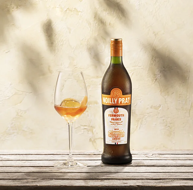 Bouteille Noilly Prat Ambré et verre avec zeste d'orange à Marseillan, vermouth doux de l'Hérault