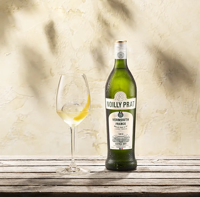 Bouteille Noilly Prat Extra Dry et verre avec zeste de citron à Marseillan, cuvée très sèche Hérault