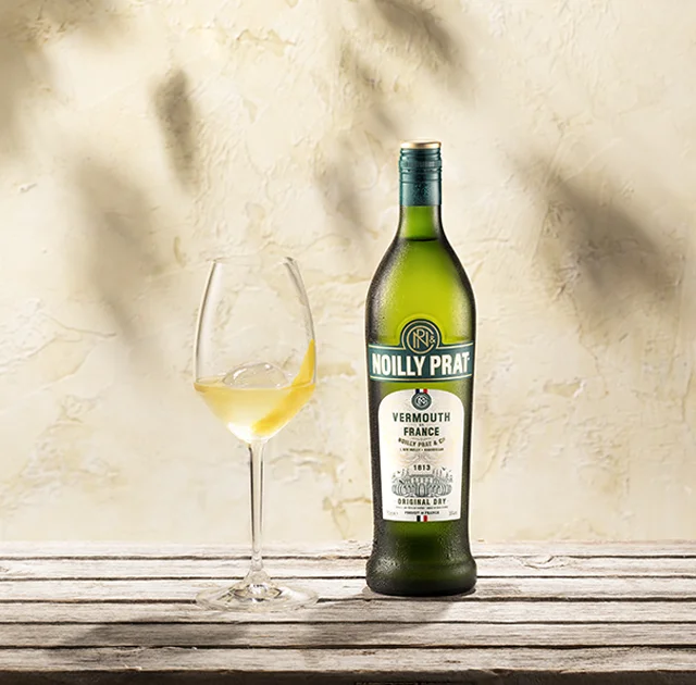 Bouteille Noilly Prat Original Dry et verre avec zeste de citron à Marseillan, vermouth de France en Hérault