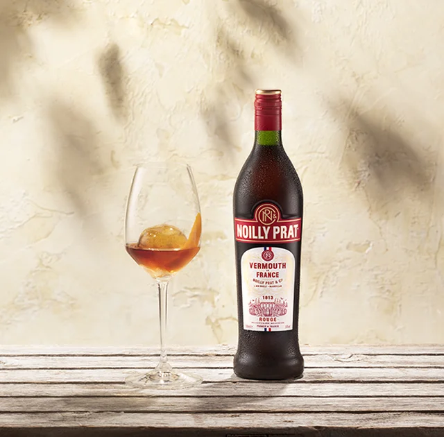 Bouteille Noilly Prat Rouge et verre avec zeste d'orange à Marseillan, vermouth rouge de France Hérault