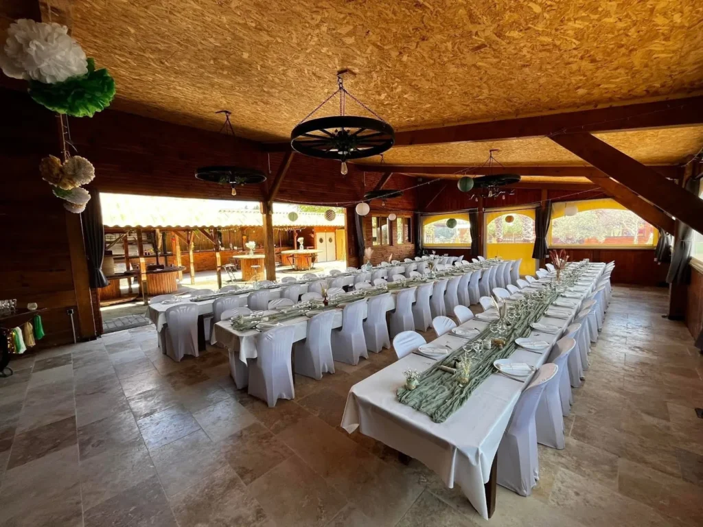 Salle de réception sous charpente bois aux tables dressées au Mas Valero à Lattes