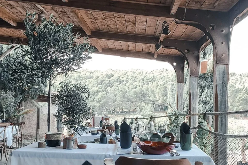 Pergola en bois abritant une table dressée avec vue sur la pinède, Château Le Bouïs