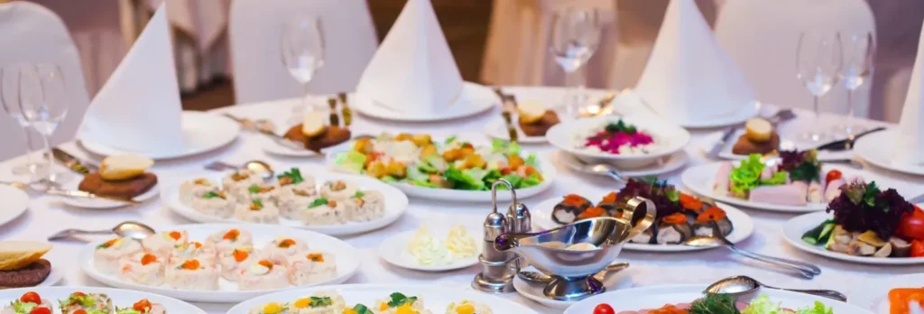 Buffet de réception dressé sur des tables nappées de blanc — Traiteur Del Païs, mariages dans l’Aude