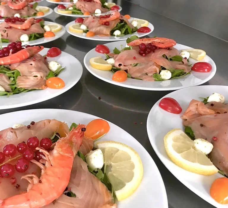 Plusieurs assiettes individuelles d’entrées froides garnies de poisson fumé et crevette rose — CKM Traiteur, mariages à Bernis