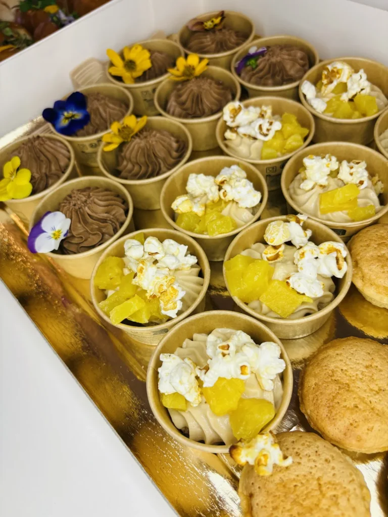 Desserts individuels : verrines au chocolat et coupes de crème ananas popcorn sur plateau doré — Hâpy Traiteur, Béziers