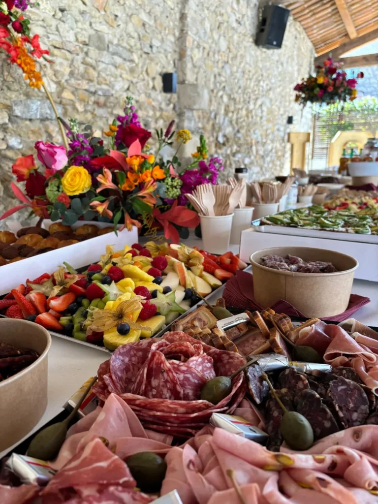 Grand buffet traiteur avec plateaux de charcuterie, fruits frais et mignardises dans un cadre rustique — Andrieux Traiteur, Lavérune