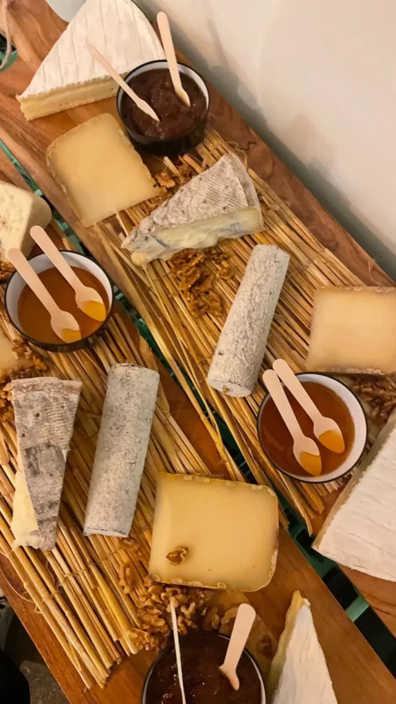 Assortiment de fromages artisanaux, noix, confitures et miel sur un plateau en bois rustique — Andrieux Traiteur, Lavérune