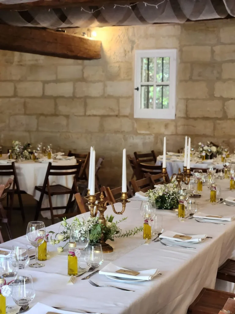 Table de mariage dressée avec nappe blanche, chandeliers dorés et compositions florales — La Petite Cuisine, Manduel