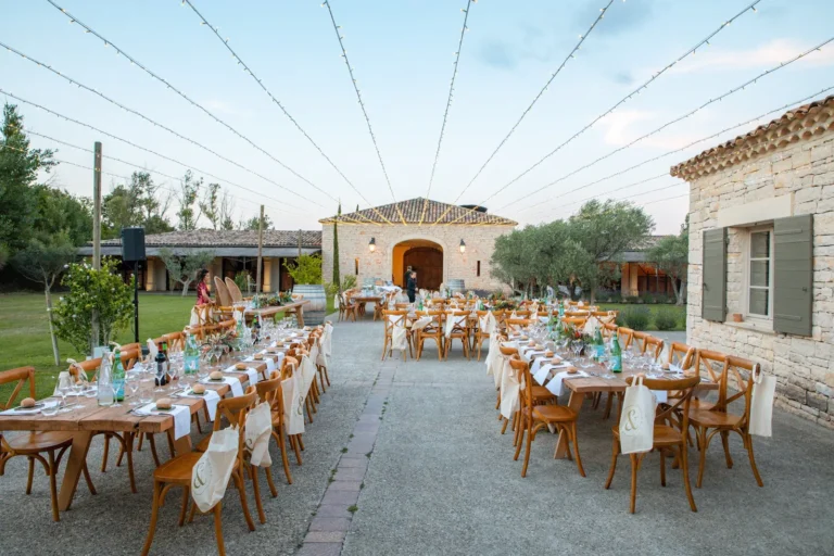 Longues tables de réception de mariage dressées en extérieur sous des guirlandes lumineuses — Traiteur d’Amélie, mariages à Mauguio