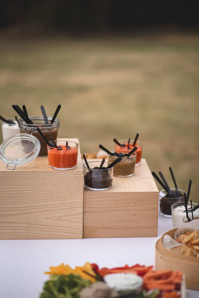 Petits pots en verre de sauces et tapenades sur des blocs de bois clairs — La Ferme des Saveurs, Méjannes-lès-Alès