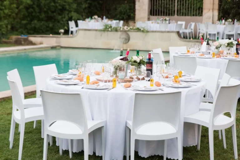 Tables rondes dressées pour un mariage au bord d’une piscine — Andrieux Traiteur, traiteur de mariage près de Montpellier