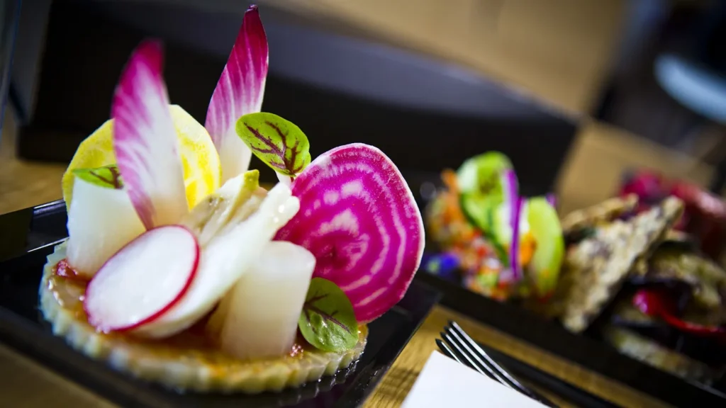 Pièce cocktail gastronomique avec radis, endive et betterave chioggia sur une base croustillante — Husser Traiteur, Montpellier