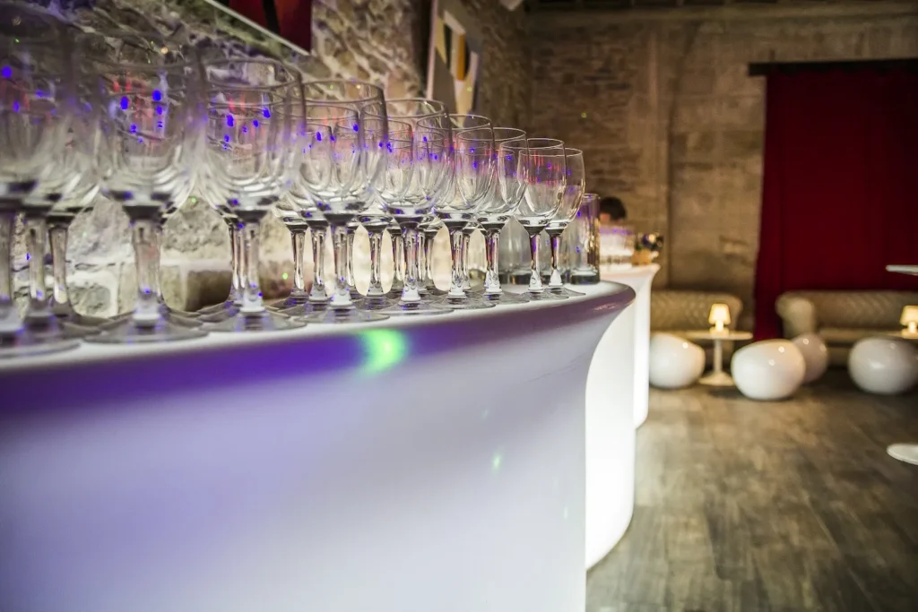 Rangée de verres à vin sur un bar lumineux moderne dans un espace de réception — Traiteur Grand, Montpellier
