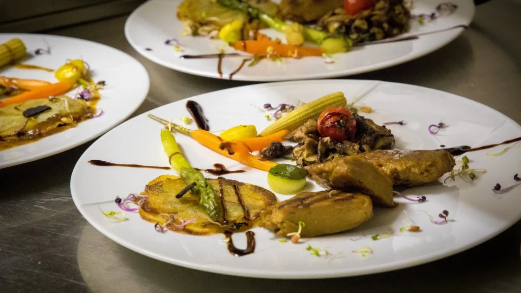 Trois assiettes gastronomiques avec légumes, viande et sauce, prêtes à être servies — Traiteur Grand, Montpellier
