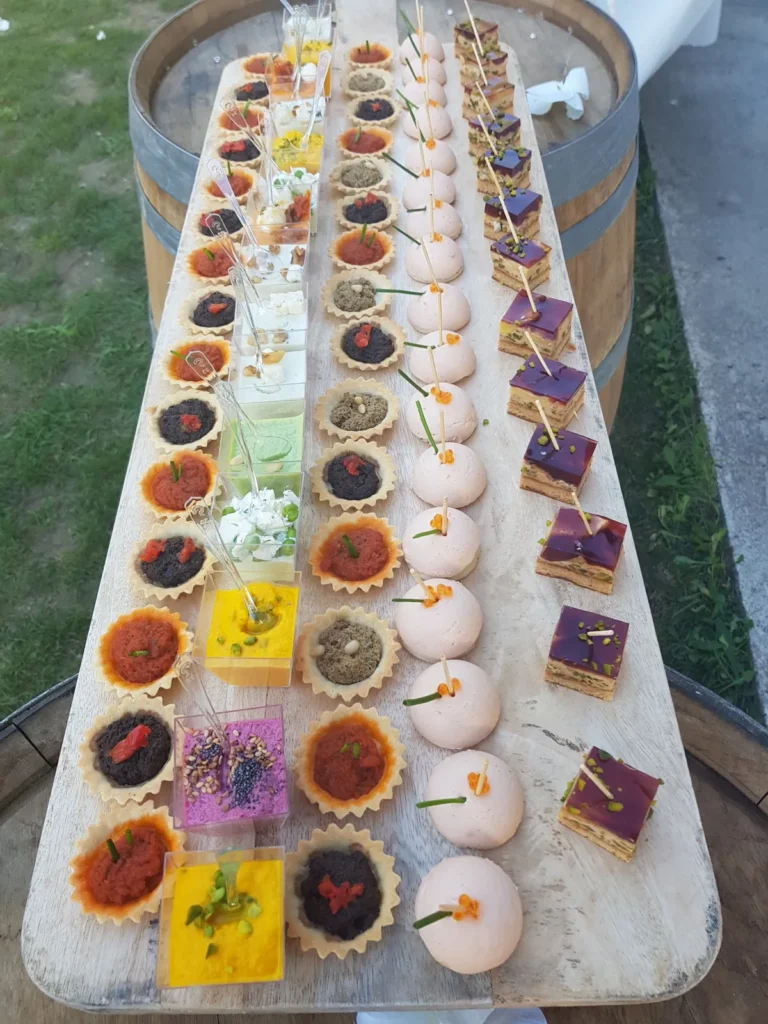 Assortiment de mignardises et amuse-bouches sur une planche en bois pour extérieur — À la Fourchette des Arènes, Nîmes
