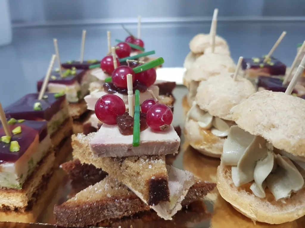 Assortiment de pièces cocktails sur un plateau doré avec foie gras et mini-choux — À la Fourchette des Arènes, traiteur de mariage à Nîmes
