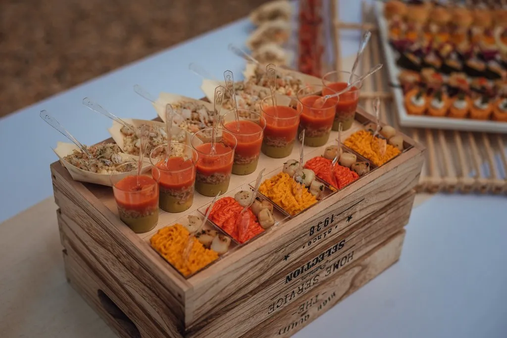 Assortiment de verrines colorées et petits plats individuels sur une caisse en bois rustique — Traiteur Niguès, Peyriac-de-Mer